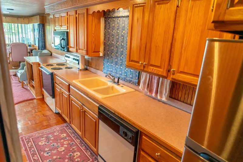Slide: The Image of 1995 Lakeview houseboat kitchen with wooden cabinets, modern appliances, and cozy dining area. - 32