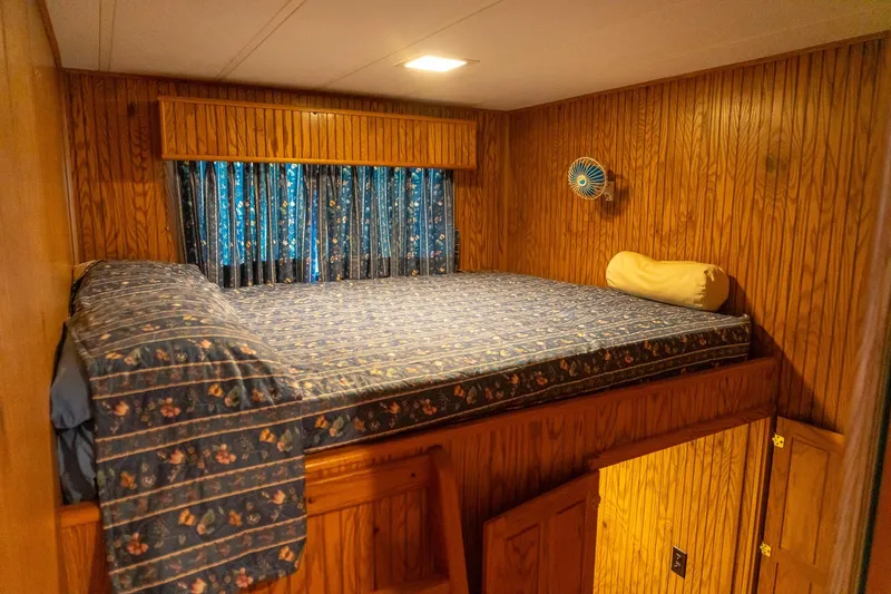 Slide: The Image of Cozy bedroom in 1995 Lakeview 62 x 14 Widebody Houseboat with wood paneling and floral bedding. - 33