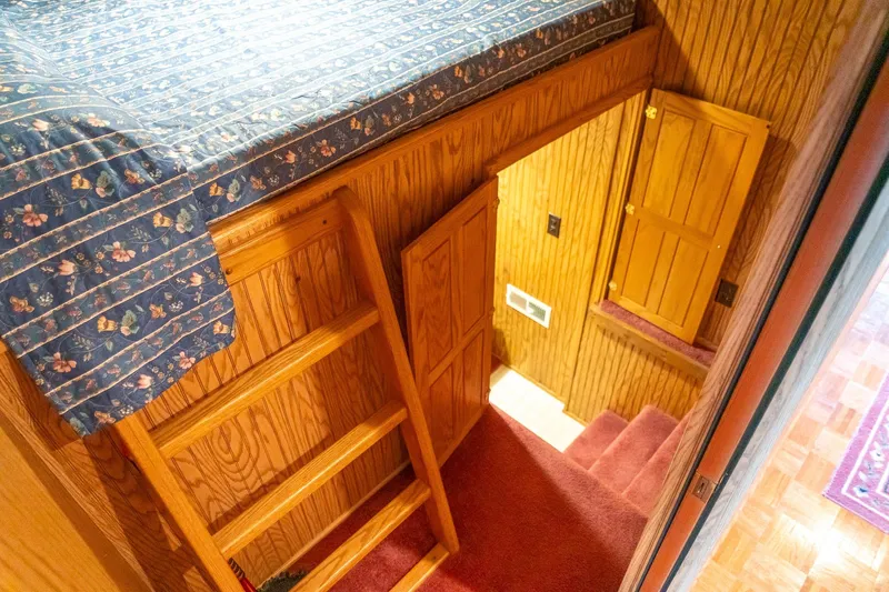 Slide: The Image of Interior of 1995 Lakeview houseboat with wooden ladder and floral bedspread. - 34