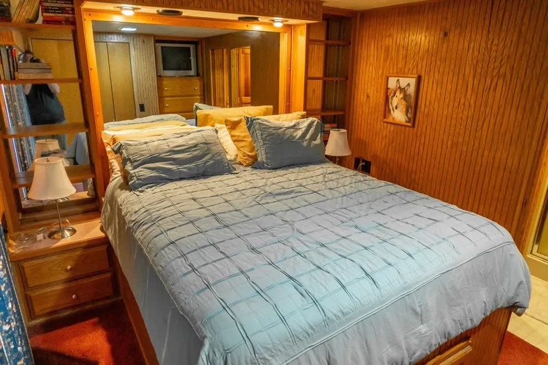 Slide: The Image of Cozy bedroom in 1995 Lakeview 62 x 14 Widebody Houseboat with wood paneling and soft lighting. - 36