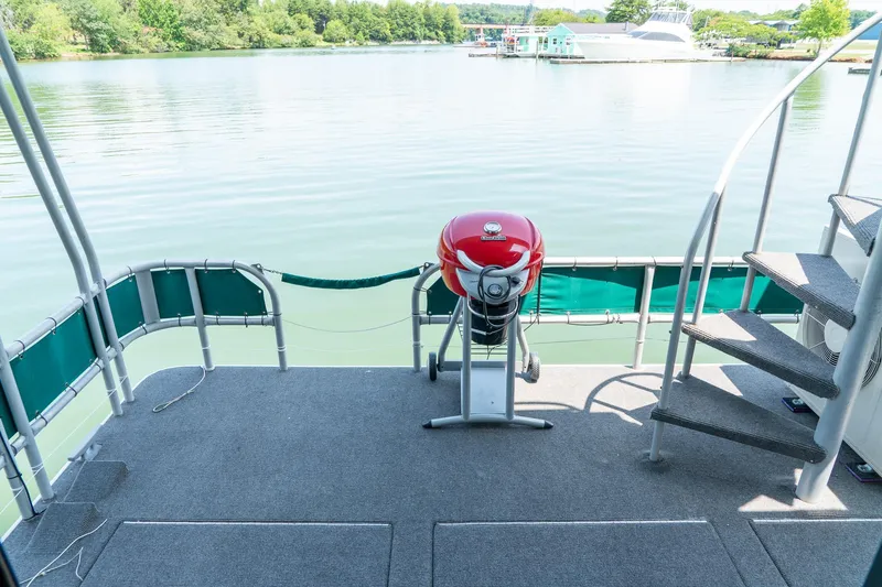 Slide: The Image of 1995 Lakeview 62 x 14 Widebody Houseboat deck with grill and lake view. - 42