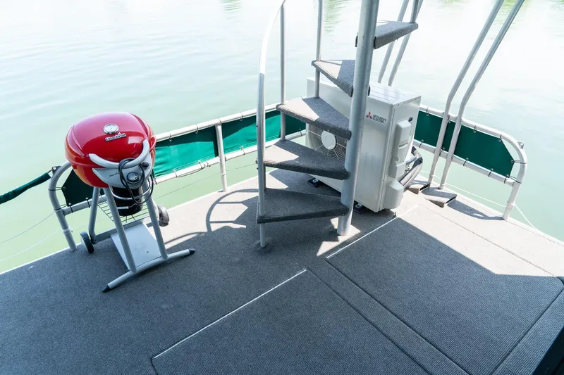 Slide: The Image of 1995 Lakeview houseboat deck with spiral stairs and red grill. - 43