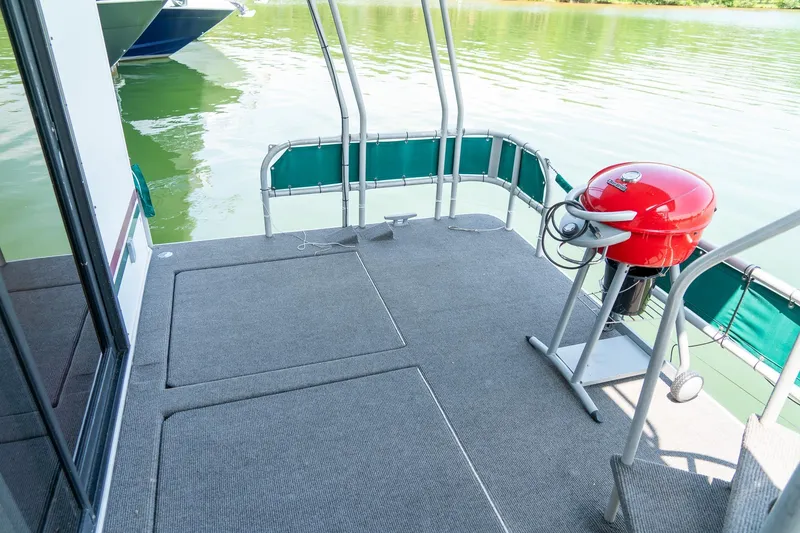 Slide: The Image of 1995 Lakeview 62 x 14 Widebody Houseboat deck with red grill and lake view. - 44