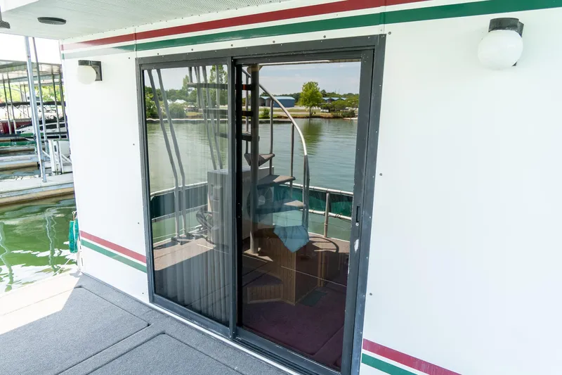 Slide: The Image of 1995 Lakeview 62 x 14 Widebody Houseboat with sliding glass door and lake view. - 45