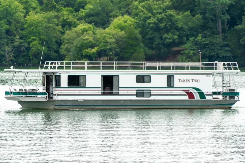 Slide: The Image of 1995 Lakeview 62 x 14 Widebody Houseboat on a serene lake with lush green background. - 5