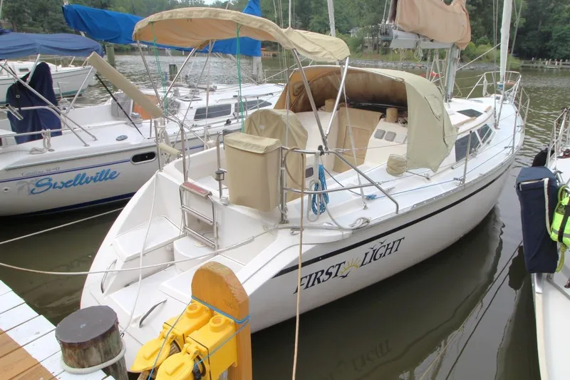 The Image of 1989 Hunter Legend 35.5 sailboat docked, named "First Light," with beige canopy. - 1