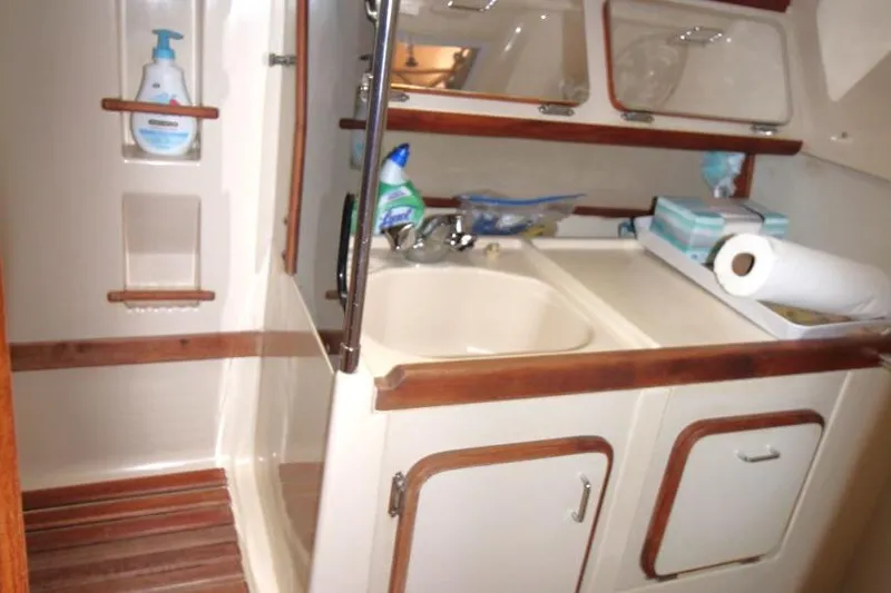 Slide: The Image of 1989 Hunter Legend 35.5 yacht bathroom with sink, cabinets, and toiletries. - 22