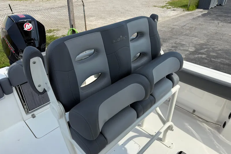 Slide: The Image of 2023 NauticStar 24 XS boat seating with gray cushioned seats and Mercury outboard motor. - 11