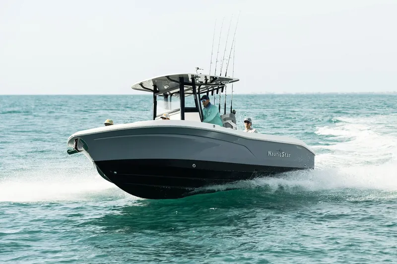 Slide: The Image of 2023 NauticStar 24 XS boat cruising on open water, featuring sleek design and fishing rods. - 13