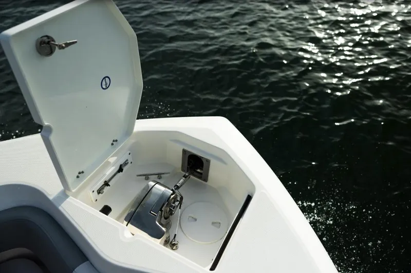 Slide: The Image of 2023 NauticStar 24 XS boat anchor compartment open on water. - 15