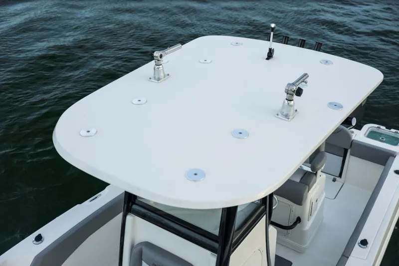 Slide: The Image of 2023 NauticStar 24 XS boat with T-top and rod holders on the water. - 16