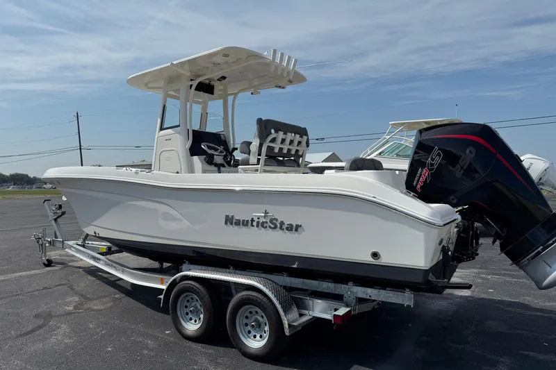 Slide: The Image of 2023 NauticStar 24 XS boat on trailer, featuring sleek design and powerful outboard motor. - 2