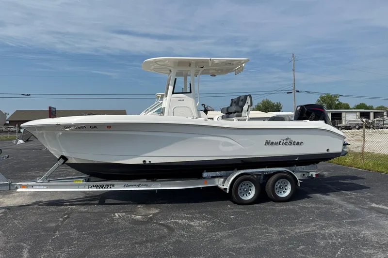 Slide: The Image of 2023 NauticStar 24 XS boat on trailer, parked outdoors under clear sky. - 4