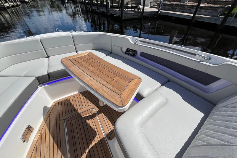 Slide: The Image of Luxurious seating area on 2022 Sea Ray SLX 310 Outboard with wooden table. - 10