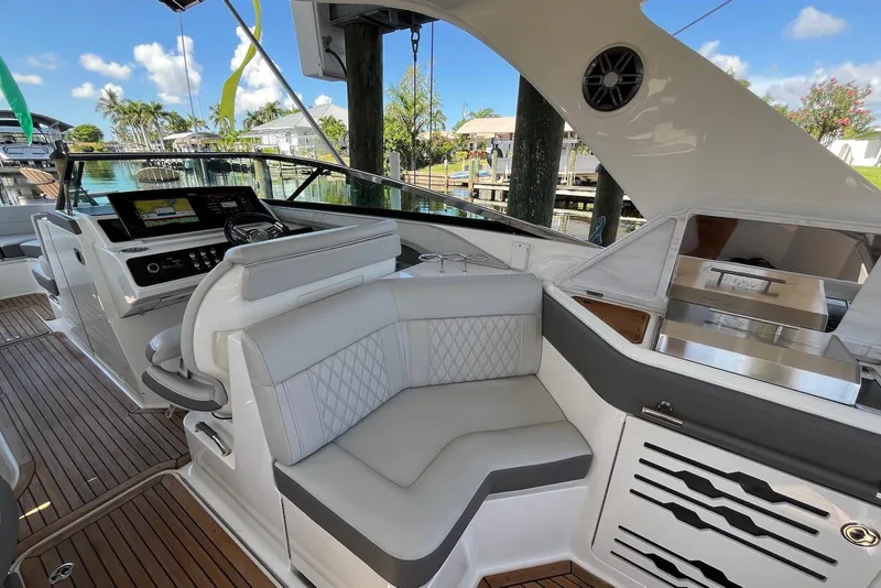 Slide: The Image of 2022 Sea Ray SLX 310 Outboard interior with luxurious seating and modern dashboard. - 16