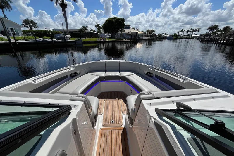 Slide: The Image of 2022 Sea Ray SLX 310 Outboard boat with luxurious seating on a sunny waterfront. - 18