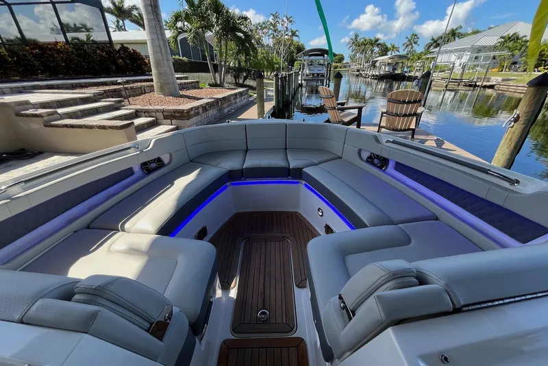 Slide: The Image of Luxurious 2022 Sea Ray SLX 310 Outboard boat interior with plush seating and ambient lighting. - 19