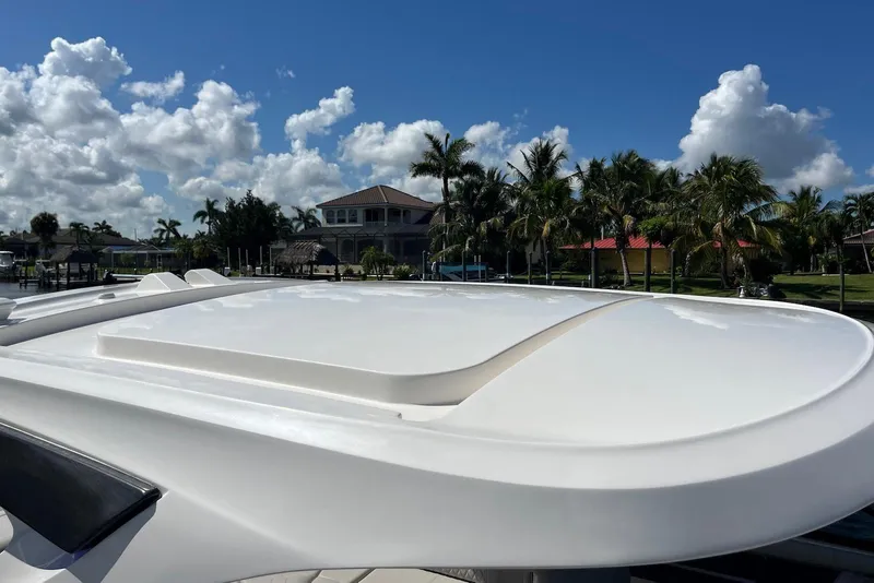 Slide: The Image of 2022 Sea Ray SLX 310 Outboard boat with sleek design, docked near palm trees. - 20