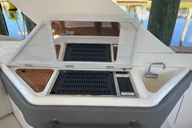 Slide: The Image of 2022 Sea Ray SLX 310 Outboard boat with onboard grill and sink setup. - 21