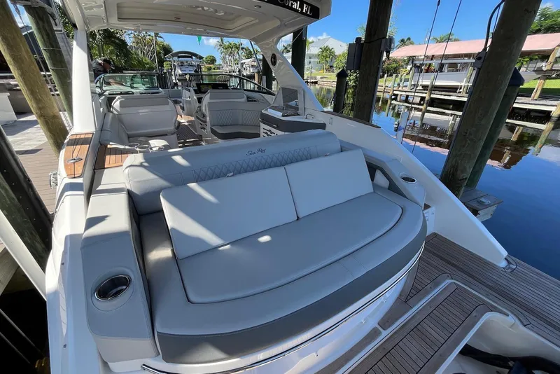 Slide: The Image of 2022 Sea Ray SLX 310 Outboard boat with luxurious seating and sleek design at a dock. - 24