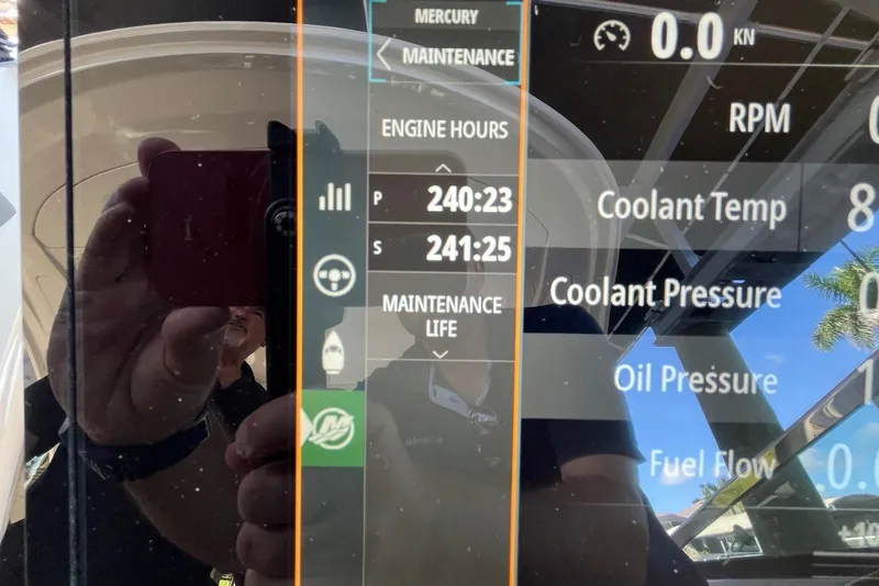 Slide: The Image of Display panel of 2022 Sea Ray SLX 310 Outboard showing engine hours and maintenance data. - 28