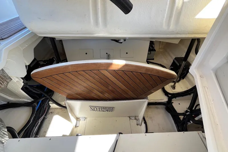 Slide: The Image of 2022 Sea Ray SLX 310 Outboard engine compartment with wooden panel and visible wiring. - 29