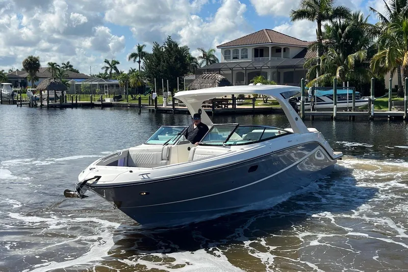 Slide: The Image of 2022 Sea Ray SLX 310 Outboard cruising in a scenic waterfront setting. - 3