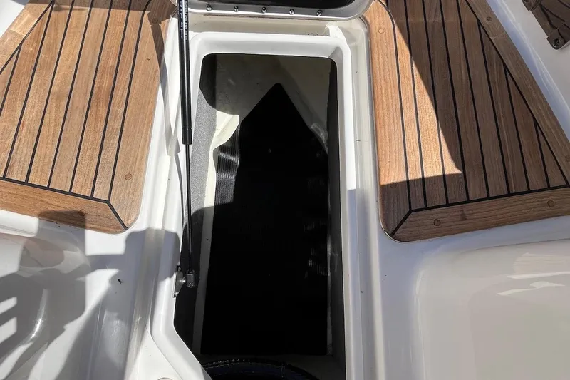 Slide: The Image of 2022 Sea Ray SLX 310 Outboard storage compartment with teak flooring. - 30