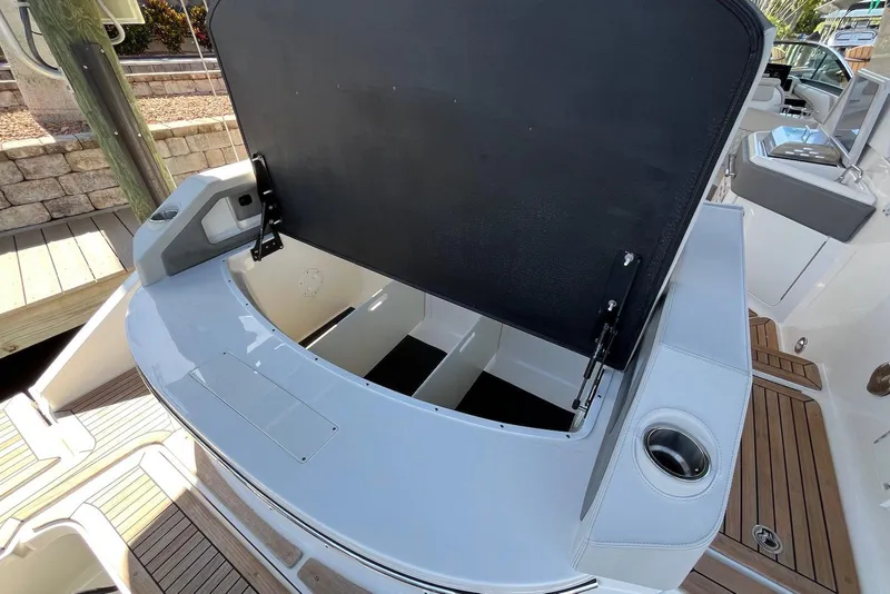 Slide: The Image of 2022 Sea Ray SLX 310 Outboard boat with open storage compartment and sleek design. - 32