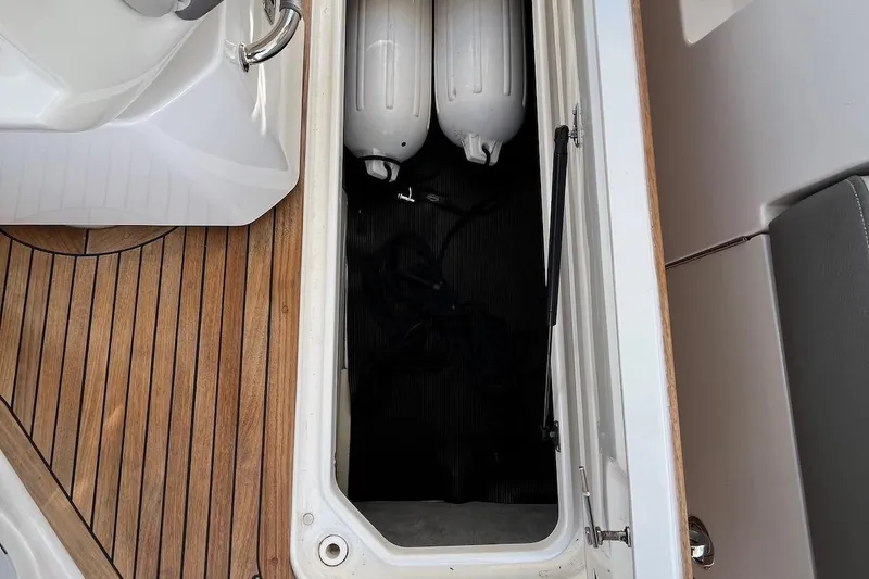 Slide: The Image of Storage compartment on 2022 Sea Ray SLX 310 Outboard with wooden deck and fenders. - 34