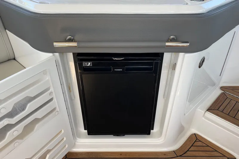 Slide: The Image of 2022 Sea Ray SLX 310 Outboard interior with built-in refrigerator and sleek design. - 35