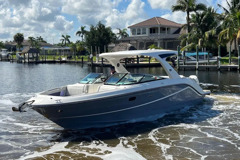 Slide: The Image of 2022 Sea Ray SLX 310 Outboard cruising on a sunny day near waterfront homes. - 4