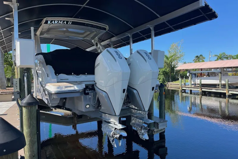 Slide: The Image of 2022 Sea Ray SLX 310 Outboard boat docked with twin engines, under a canopy. - 41