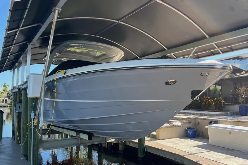 Slide: The Image of 2022 Sea Ray SLX 310 Outboard boat docked under a covered lift. - 42