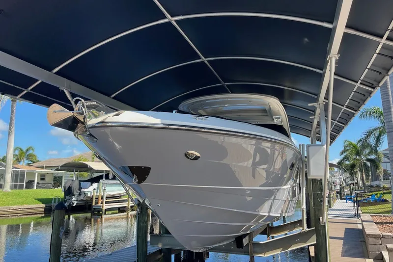 Slide: The Image of 2022 Sea Ray SLX 310 Outboard boat docked under a canopy, side view. - 43