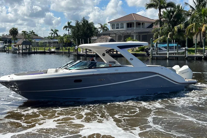 Slide: The Image of 2022 Sea Ray SLX 310 Outboard cruising on a sunny day near waterfront homes. - 5