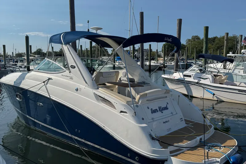 The Image of 2012 Sea Ray 280 Sundancer boat docked in marina, featuring sleek design and blue accents. - 0