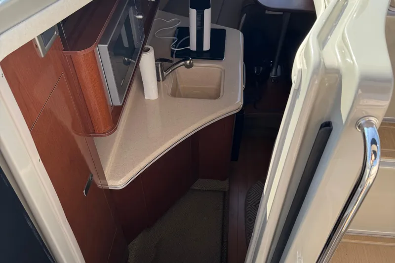 Slide: The Image of Interior view of 2012 Sea Ray 280 Sundancer boat kitchen area with sink and countertop. - 15