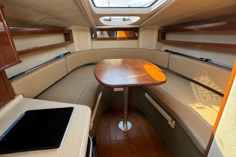Slide: The Image of 2012 Sea Ray 280 Sundancer cabin interior with seating, table, and skylight. - 16