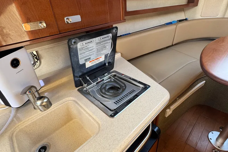 Slide: The Image of Interior of 2012 Sea Ray 280 Sundancer with stove, sink, and seating area. - 18
