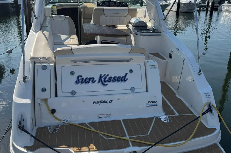 Slide: The Image of 2012 Sea Ray 280 Sundancer boat docked, featuring "Sun Kissed" name on the stern. - 2