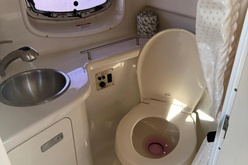 Slide: The Image of 2012 Sea Ray 280 Sundancer bathroom with sink, toilet, and shower curtain. - 24