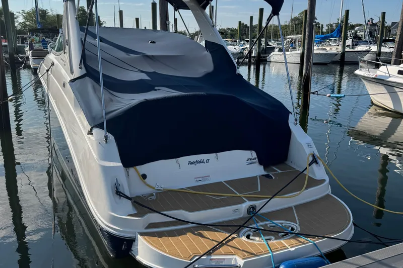 Slide: The Image of 2012 Sea Ray 280 Sundancer docked, covered with a navy blue tarp. - 26