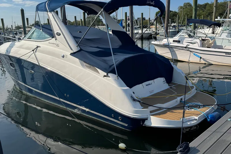 Slide: The Image of 2012 Sea Ray 280 Sundancer docked at marina, featuring sleek design and blue canopy. - 27