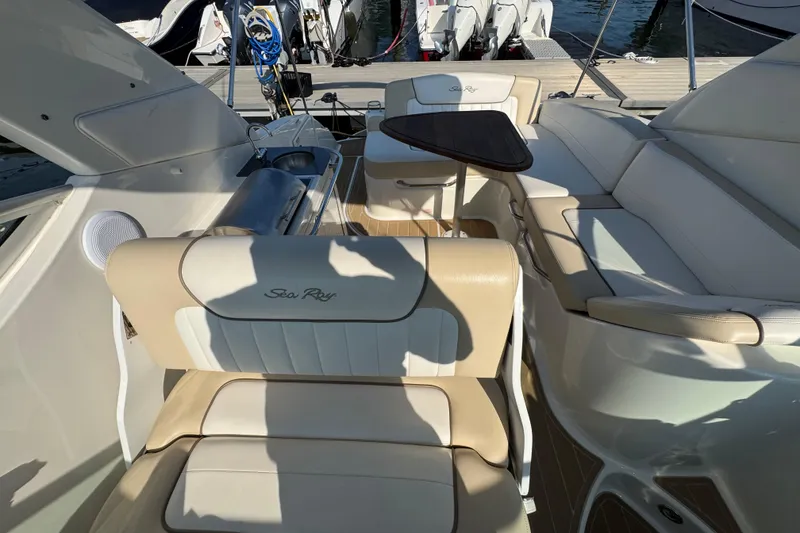 Slide: The Image of Interior of 2012 Sea Ray 280 Sundancer with beige seating and wooden table. - 8