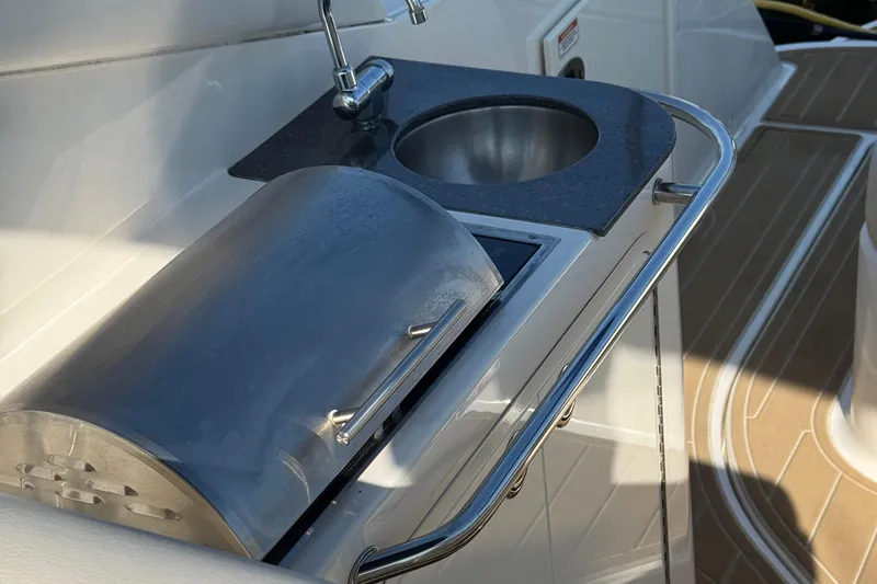 Slide: The Image of Outdoor kitchenette on a 2012 Sea Ray 280 Sundancer boat with sink and grill. - 9