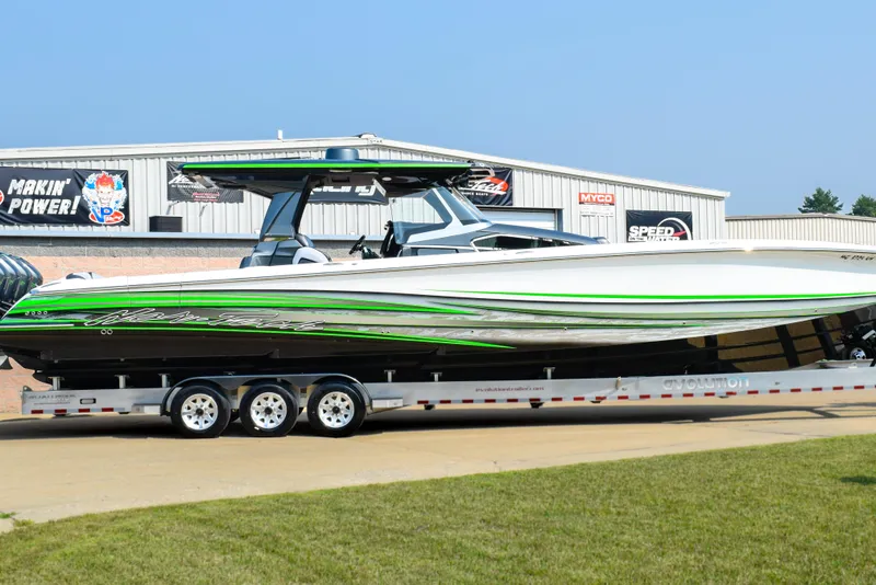 The Image of 2019 Nor-Tech 450 Sport Center Console boat on trailer, featuring sleek green and white design. - 1