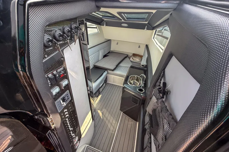 Slide: The Image of 2019 Nor-Tech 450 Sport Center Console cabin interior with modern design and carbon fiber accents. - 10