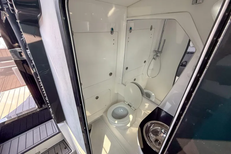 Slide: The Image of 2019 Nor-Tech 450 Sport Center Console bathroom with toilet and shower. - 11