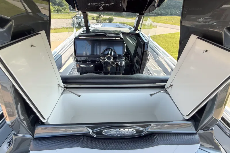 Slide: The Image of 2019 Nor-Tech 450 Sport Center Console interior with open storage compartments and sleek dashboard. - 16